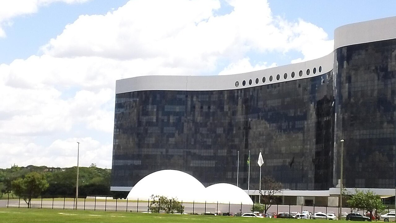 A modern multi-storey government court building with a glass and stone façade under a clear sky in Brasília.