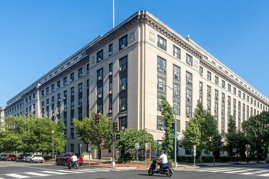 The pale stone General Services Administration headquarters building in Washington, DC, seen from a street corner under a clear blue sky