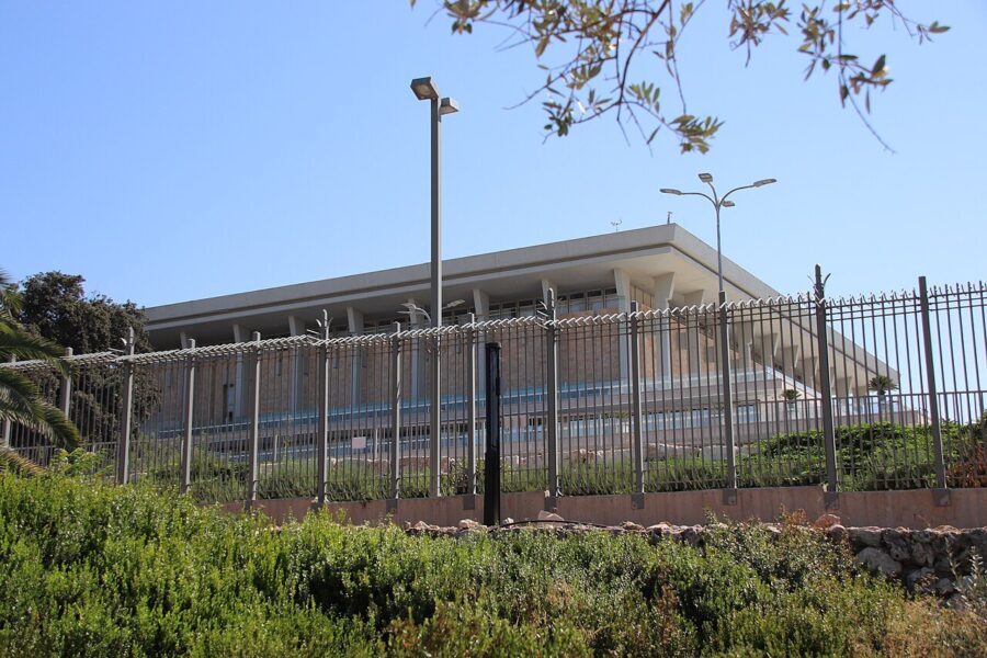 The rectangular colonnaded Knesset building in Jerusalem under a clear sky