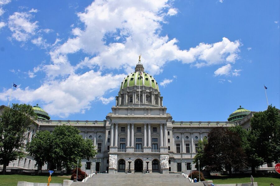 The domed Pennsylvania State Capitol building in Harrisburg, seen from outside under a clear sky.