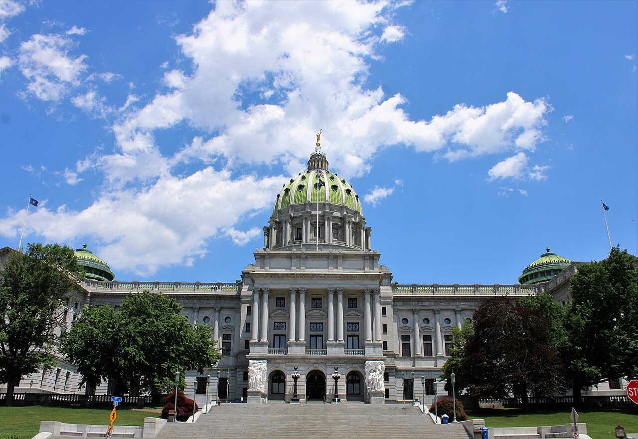 The domed Pennsylvania State Capitol building in Harrisburg, seen from outside under a clear sky.