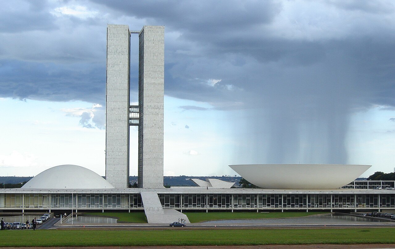 The twin towers and domes of Brazil's National Congress building in Brasília under a rainy sky